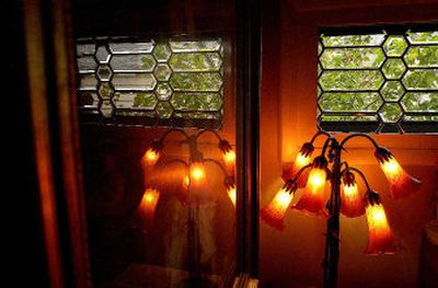 
A mix of antiques and new lighting complement original leaded glass windows in the Lobdell bungalow. The tulip lamp is reflected in vintage framed artwork. 
 (Photos by BRIAN PLONKA / / The Spokesman-Review)