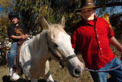
Mark Phillpy, right, leads Lonnie Kohrdt, 11, on his first horseback ride.
 (Photo by INGRID BARRENTINE / The Spokesman-Review)