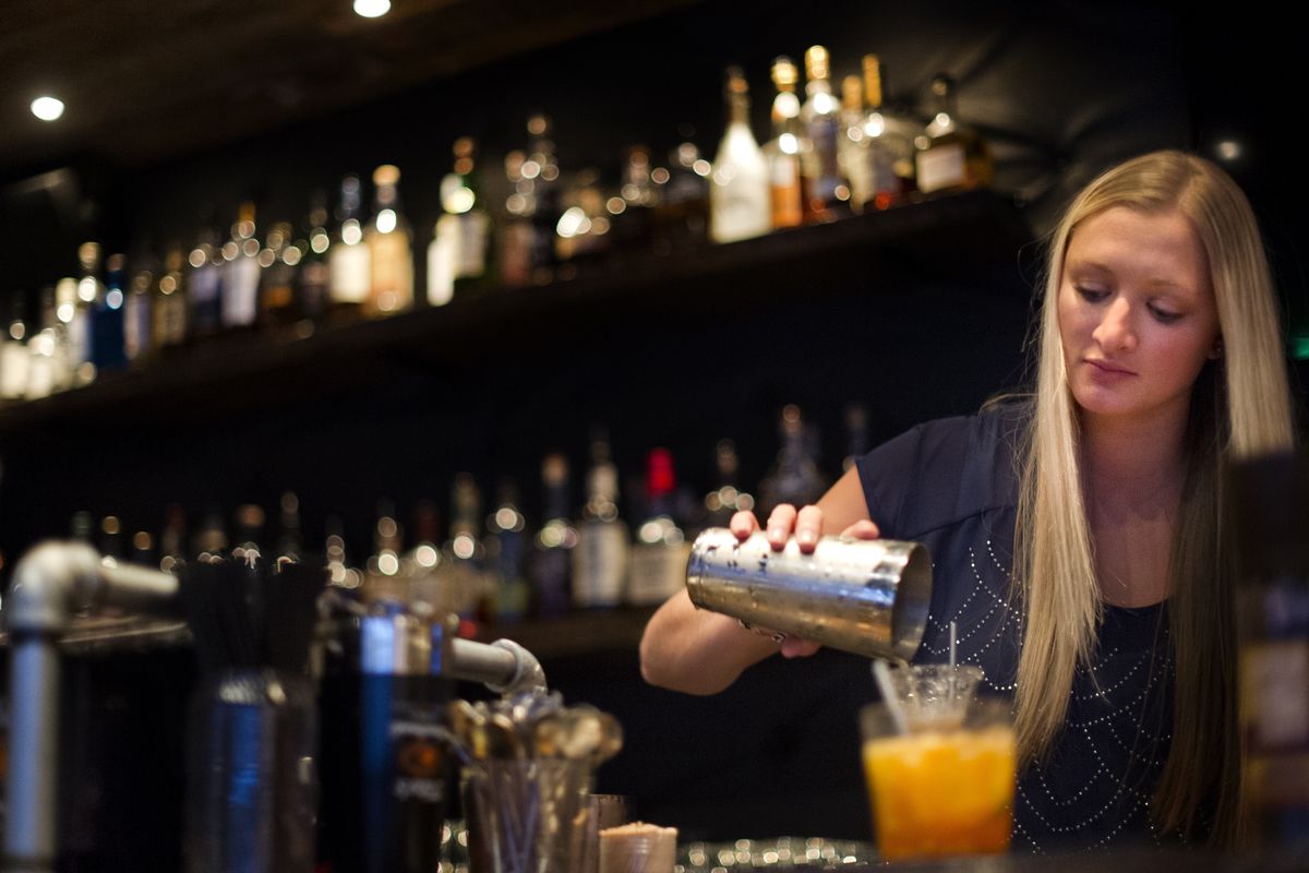 Bartender Brittny Gudmunson prepares a pair of drinks at Volstead Act, a downtown bar that specializes in cocktails from the pre-Prohibition era. (Tyler Tjomsland)