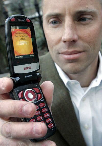
Paul Martjuchin, a controller for Credit Suisse First Boston, holds his Mobile ESPN branded cell phone, in New York. 
 (Associated Press / The Spokesman-Review)