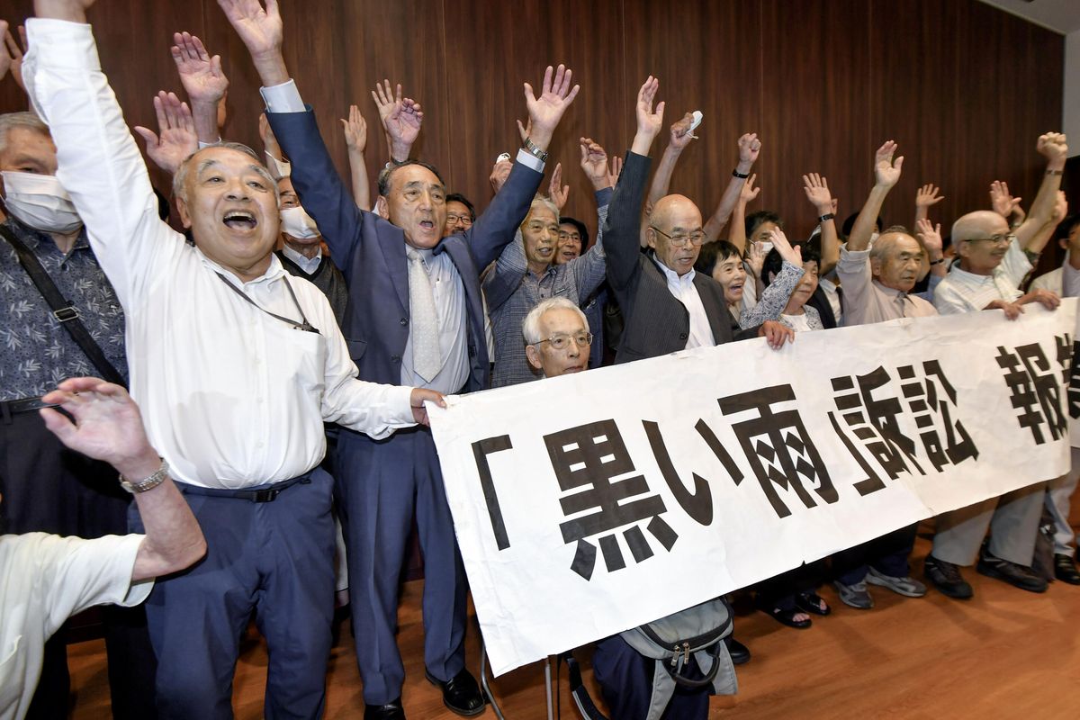 A group of plaintiffs and supporters celebrate during a meeting following the court ruling in Hiroshima, western Japan, Wednesday, July 29, 2020. A court has recognized people exposed to radioactive “black rain” that fell after the U.S. atomic attack on Hiroshima as atomic bomb survivors, ordering the government to provide the same medical benefits it gives other survivors.  (115323+0900)