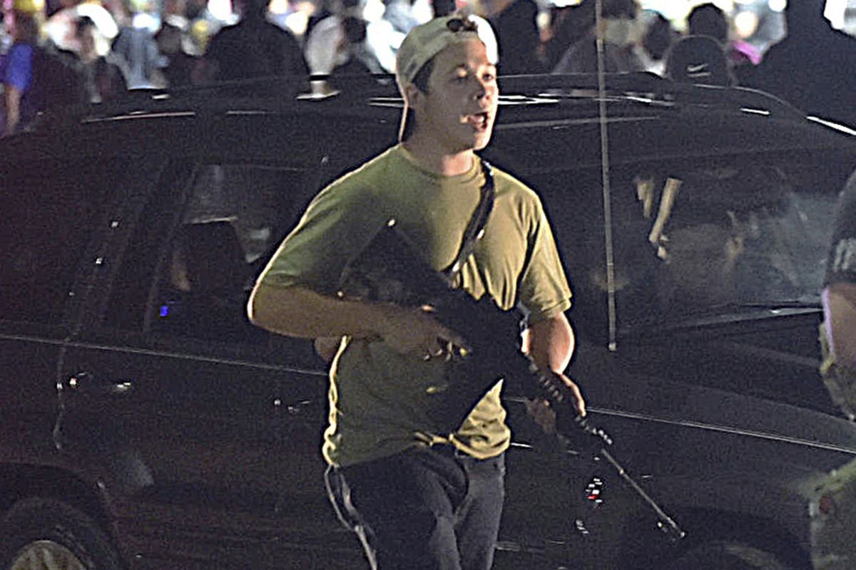 FILE - In this Aug. 25, 2020, file photo, Kyle Rittenhouse carries a weapon as he walks along Sheridan Road in Kenosha, Wis., during a night of unrest following the weekend police shooting of Jacob Blake. Rittenhouse is white. So were the three men he shot during street protests in Kenosha in 2020. But for many people, Rittenhouse