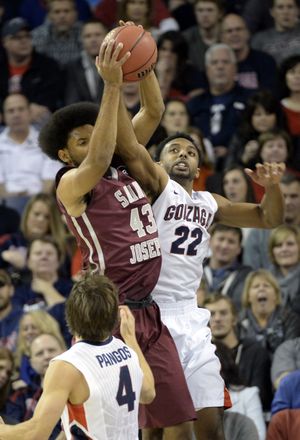 Gonzaga's Byron Wesley, right, gets a hand on the rebound grabbed by St. Joseph's DeAndre Bembry, center, as Kevin Pangos looks on below in the first half Wednesday, Nov. 19, 2014 at the McCarthey Athletic Center. An ugly game ended the half with the Zags up 48-10. (Jesse Tinsley / The Spokesman-Review)