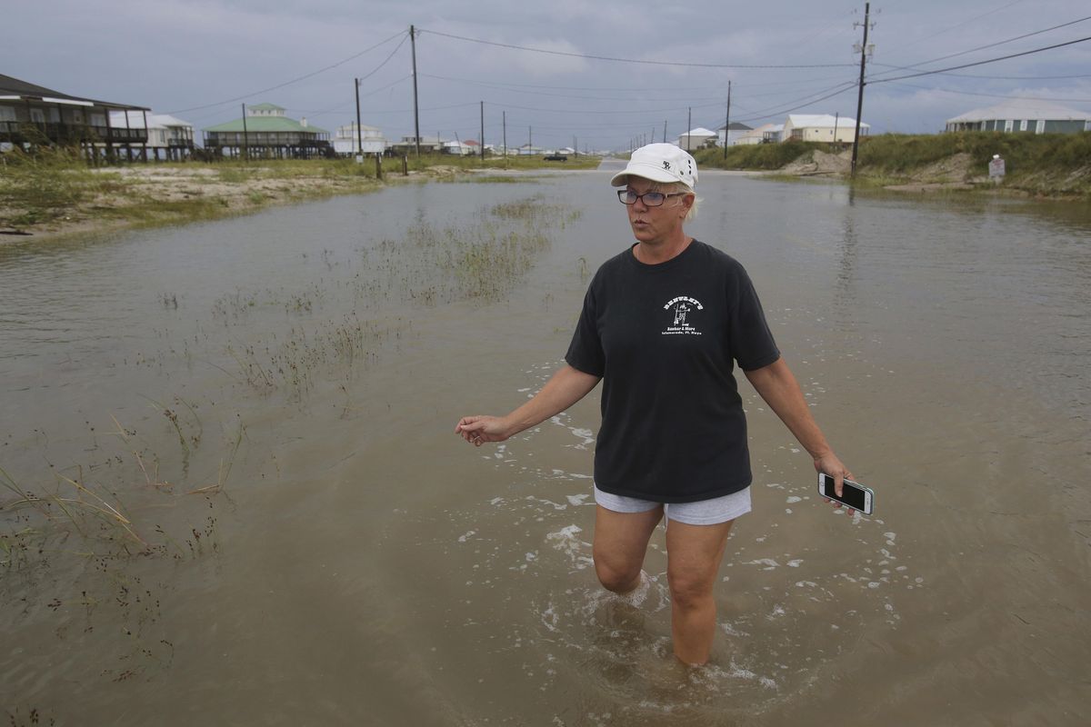 Susan Jones walks through a flooded road from Tropical Storm Gordon, Wednesday, Sept. 5, 2018, in Dauphin Island, Ala. (Dan Anderson / Associated Press)