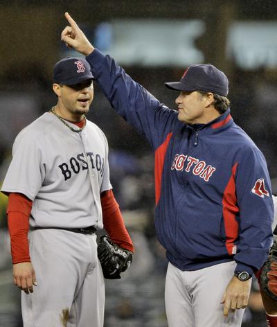 Red Sox pitching coach John Farrell gestures for a reliever after starter Josh Beckett strained his back on Tuesday. (Associated Press)