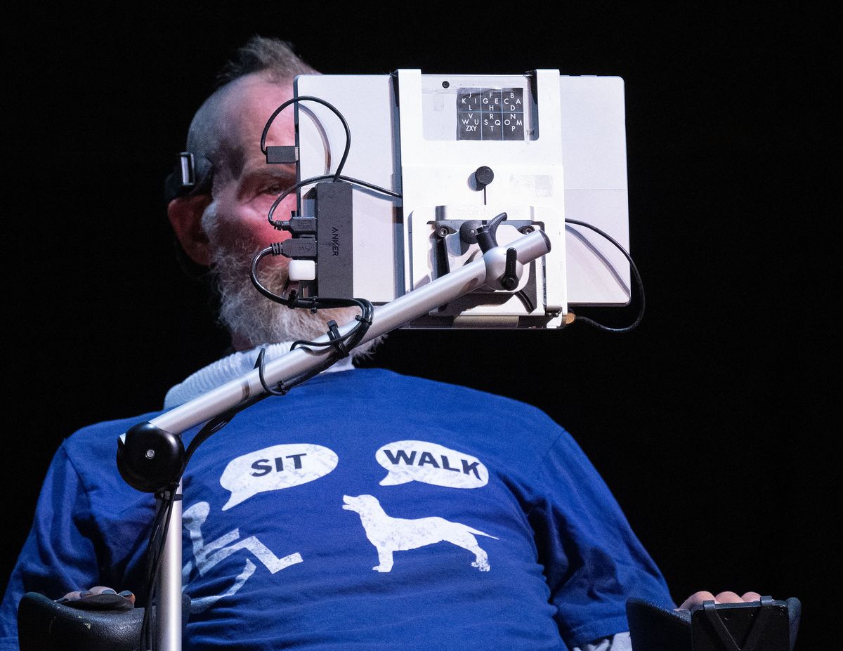 On stage, Steve Gleason, who has ALS, uses special eye-tracking technology to trigger pre- recored audio responses to questions during a Northwest Passages event, Sunday, Aug 4, 2024, at the Myrtle Woldson Performing Arts Center.  (COLIN MULVANY/THE SPOKESMAN-REVIEW)