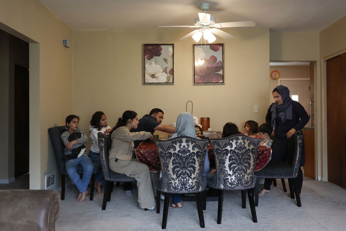 The Azizi family gathers at the dinner table for snacks after school at their home in the West Ridge neighborhood on May 2, 2025, in Chicago. The family fled to Kabul, then Pakistan and Qatar, finally arriving in the U.S. in April.   (John J. Kim/Chicago Tribune/TNS)