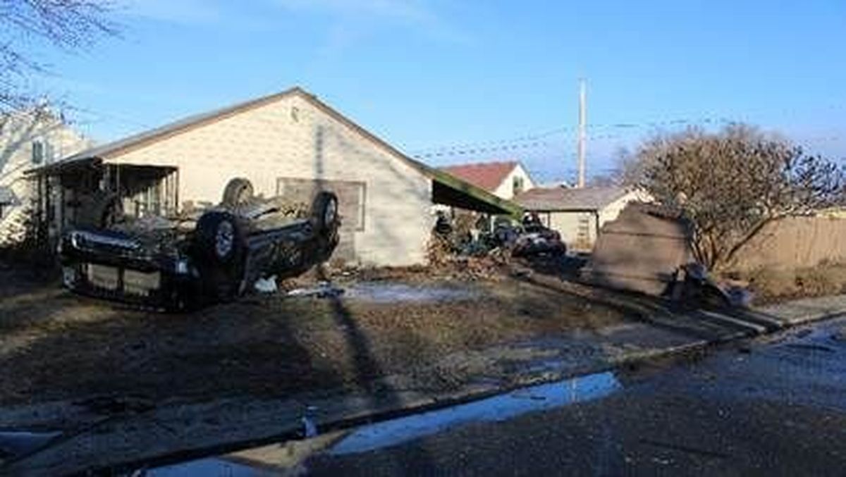 The driver of a car reportedly ran a stop sign and struck this truck, causing it to flip on its top in a yard, Friday morning at the intersection of Queen Avenue and Alberta Street in Spokane, according to the Spokane Police Department. A man and his young child in the truck had minor injuries, while the driver of the car, Gavin Burndt, 22, sustained substantial injuries and was taken to a hospital. He also faces charges for the crash and a previous crash that morning.   (Courtesy of Spokane Police Department)