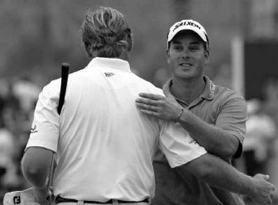 Sweden's Henrik Stenson, right, receives a hug from Ernie Els after winning the Dubai Desert Classic golf tournament.
(Associated Press / The Spokesman-Review)