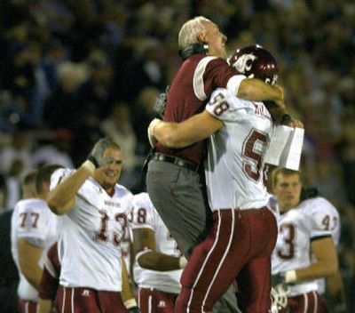 Cougars defensive coordinator Robb Akey hugs defensive end Matt Mullenix. 
 (Christopher Anderson/ / The Spokesman-Review)