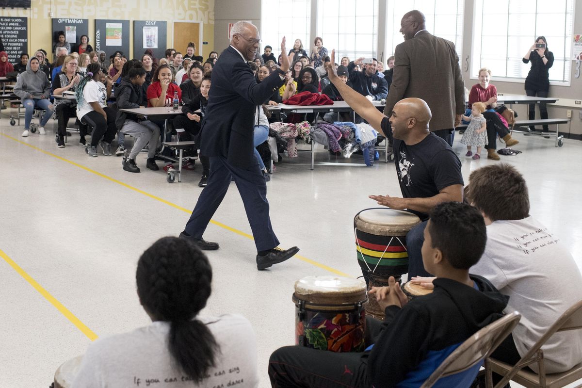 Delano Lewis, the former U.S. Ambassador to South Africa under President Clinton, left, high-fives David Casteal of Cooper Drummers & Dancers after they performed following Lewis