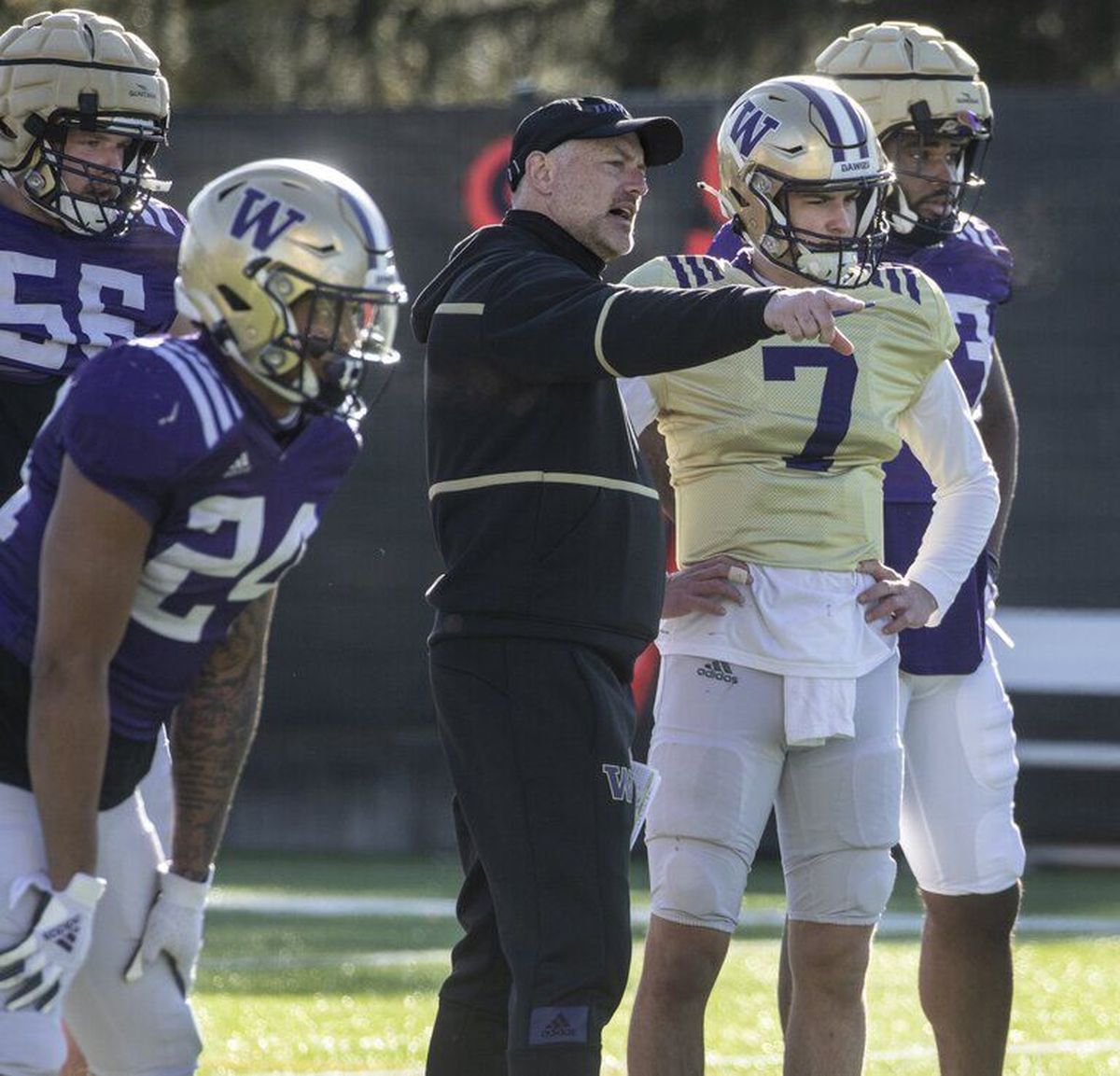 Washington Huskies offensive cordinator John Donovan talks with players, including quarterback Sam Huard (7), before a drill at spring practice on Monday.  (Steve Ringman / The Seattle Times)