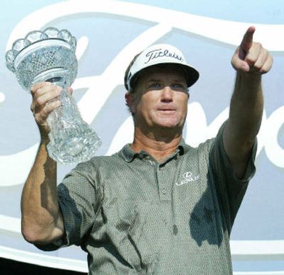 
Peter Jacobsen holds up the Senior Players Championship trophy after winning by one stroke over Hale Irwin on Sunday.
 (Associated Press / The Spokesman-Review)