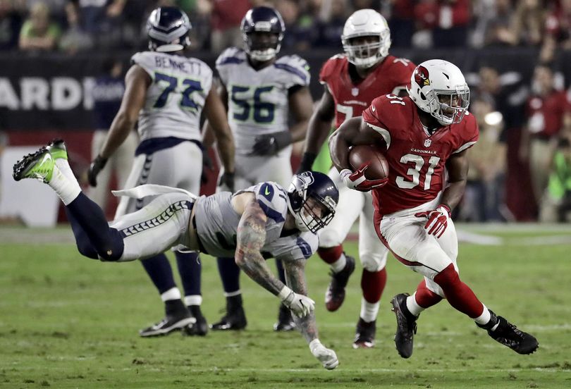 Arizona Cardinals running back David Johnson (31) slips past Seattle Seahawks defensive end Cassius Marsh (91) during the first half Sunday. (Rick Scuteri / Associated Press)