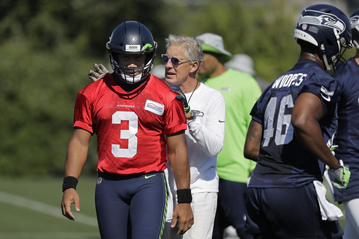 Seahawks coach Pete Carroll, back, will once again rely on quarterback Russell Wilson to find a way to win games. (Ted S. Warren / AP)