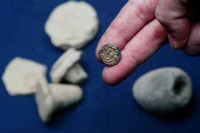 An ancient coin is seen with other items discovered at the site.
(Associated Press / The Spokesman-Review)