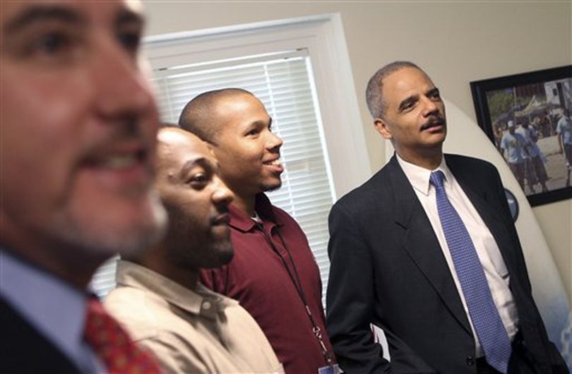 U.S. Attorney General Eric Holder, right, tours the Institute for the Study and Practice of Nonviolence in Providence, R.I., Thursday, June 2, 2011. With Holder are Teny Gross, left, executive director of the institute, Ajay Benton, second from left, and Juan Carter, third from left. Holder promised Thursday to clarify the Justice Department's position on state medical marijuana laws after federal prosecutors warned they might prosecute everyone from licensed growers to regulators. ((AP Photo/Bob Thayer, Pool))