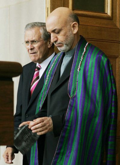 
Defense Secretary Donald H. Rumsfeld escorts Hamid Karzai from the Pentagon after their meeting Monday. 
 (Associated Press / The Spokesman-Review)