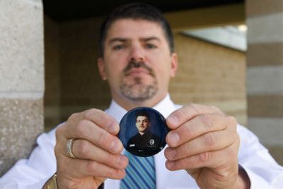 
Jim Studer  displays on Sept. 12  the button bearing the picture of his slain brother  that he wore  at the trial of Mathew Musladin. 
 (File Associated Press / The Spokesman-Review)