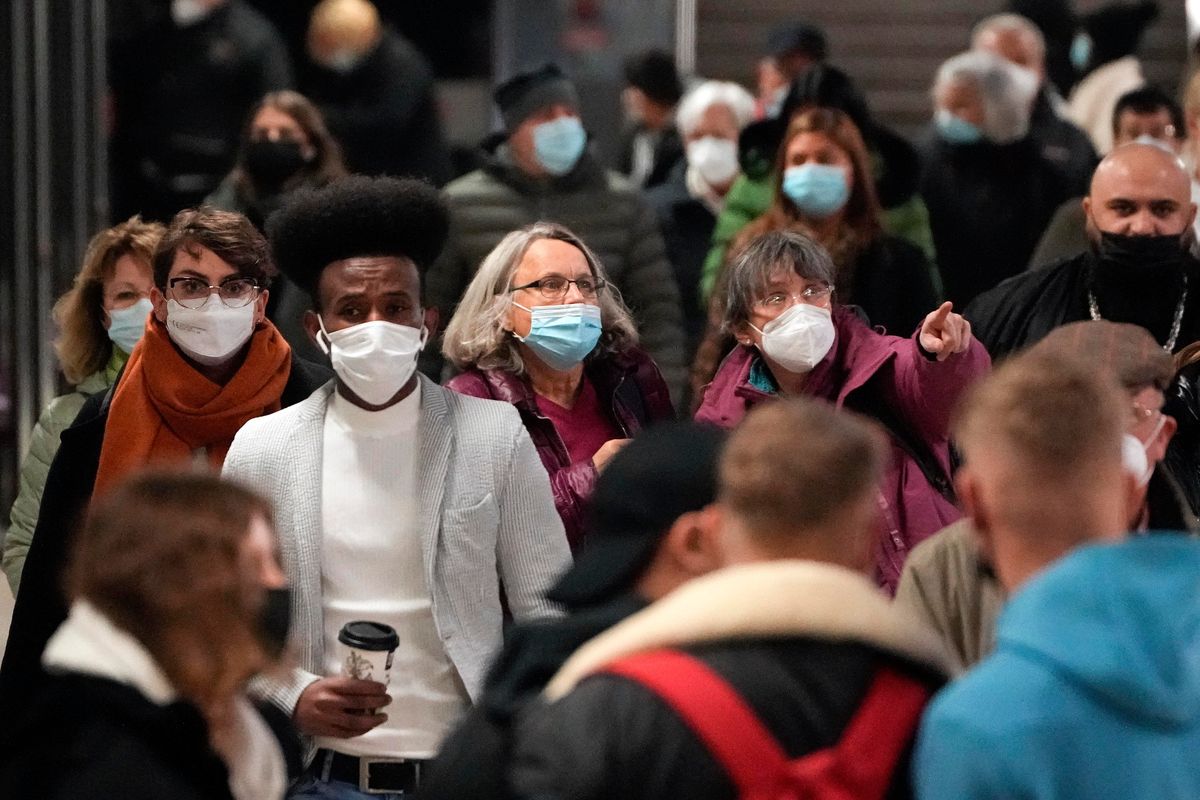 People wear mandatory face masks as the leave the subway in Cologne, Germany, Wednesday, Nov. 17, 2021. Germany