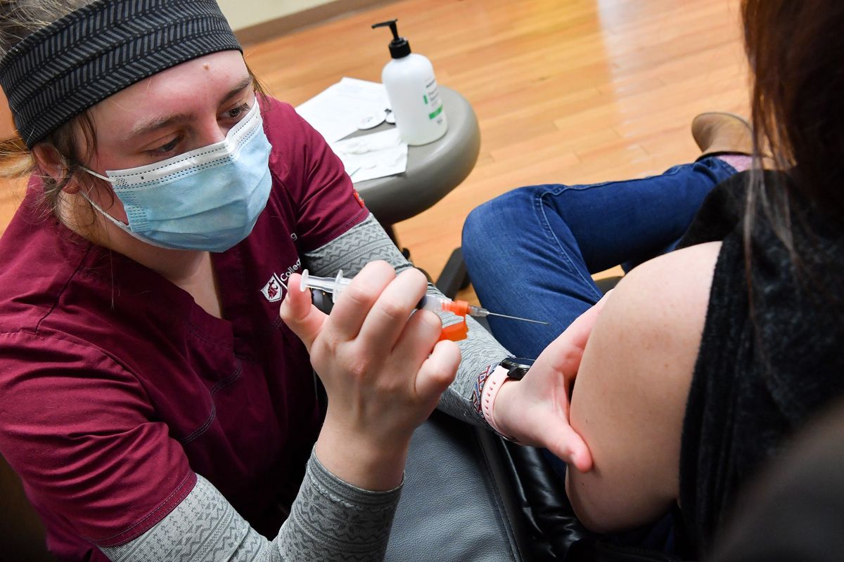 Jennifer Leick receives a COVID-19 vaccine from Washington State University nursing student Erin McLeod at Summit Cancer Centers in Spokane in January 2021. While WSU didn’t receive any state Legislature money this year to expand their nursing program, other programs did. It’s all based on what a school asks for, lawmakers say.  (Tyler Tjomsland/The Spokesman-Review)