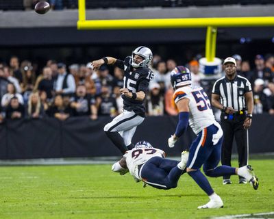 Raiders quarterback Gardner Minshew (15) gets rid of the ball on a scramble as Denver Broncos defensive tackle Malcolm Roach (97) takes out his feet during the second half of their NFL game at Allegiant Stadium on Sunday, Nov. 24, 2024, in Las Vegas.   (Tribune News Service)