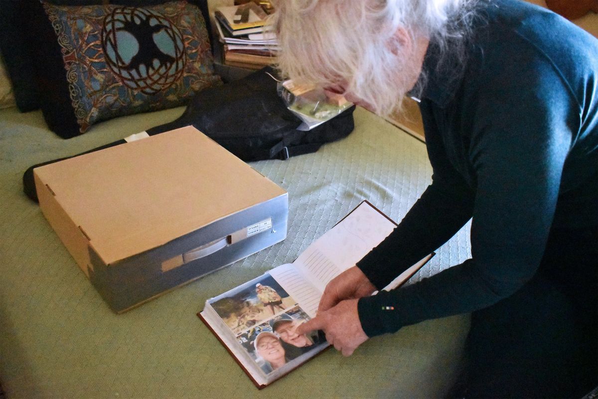 Jennifer Mitchell looks through pictures of travels with her husband, Bill. Bill died shortly after being discharged from the Montana State Hospital. (Aaron Bolton/Montana Public Radio/KHN/TNS)