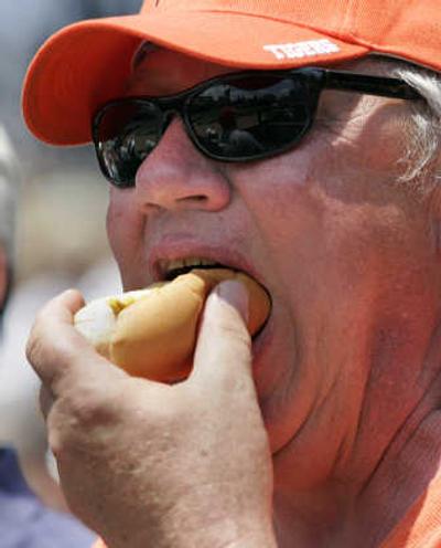
Mike Browning, of St. Clair, Mich., enjoys a Ball Park frank at Comerica Park in Detroit.
 (The Spokesman-Review)