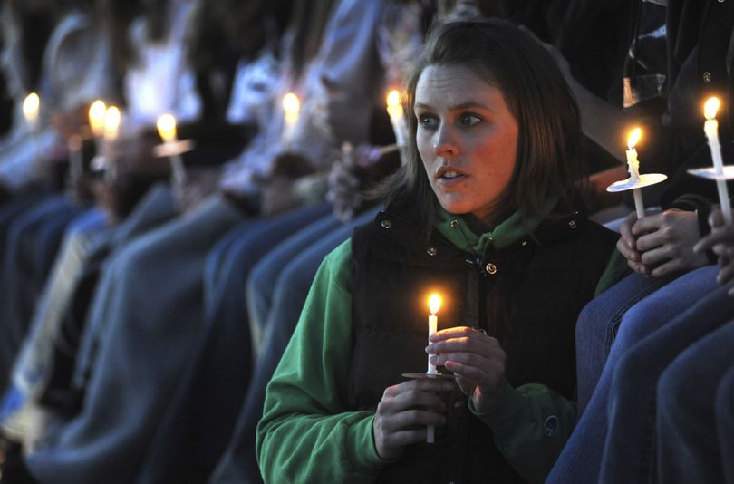 ORG XMIT: COEA110 Jen Beaver, 23, holds her candle as she watches the candlelight vigil at the Columbine Memorial at Clement Park near Littleton, Colo., on Sunday, April 19, 2009.  (AP Photo/Chris Schneider) (Chris Schneider / The Spokesman-Review)