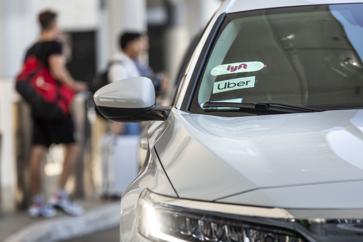 Lyft and Uber Technologies stickers are displayed on the windshield of a vehicle at Los Angeles International Airport in 2019. (Allison Zaucha/Bloomberg)
