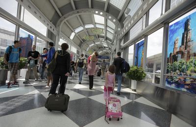 Travelers make their way through Chicago’s O’Hare International Airport last week. Many areas are imposing extra taxes on travelers to help raise revenue. (File Associated Press / The Spokesman-Review)