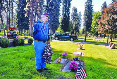 
Jim Shepperd, of Coeur d'Alene, stops and salutes the grave of a friend after pushing a small American flag into the sod beside the grave at Forest Cemetery on Friday. Shepperd is a WWII Navy veteran and a member of the Veterans of Foreign Wars. 
 (Jesse Tinsley / The Spokesman-Review)