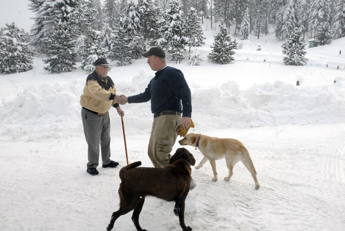Randy Krum, along with his chocolate lab Abbey and yellow lab Bella, greet Lloyd Phillips at the end of 44th Avenue near Chester Hills in the Spokane Valley Dec. 23. Phillips used to ski and ice skate at Ski-Mor ski resort, built at that location by the Schafer family. Krum recently purchased 20 acres and was plowing his road when the two met up.  (J. BART RAYNIAK / The Spokesman-Review)