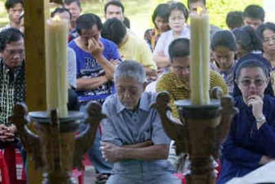 
Villagers pray outside a Catholic church at Gunung Sitoli, Nias Island, Indonesia, on Sunday. 
 (Associated Press / The Spokesman-Review)