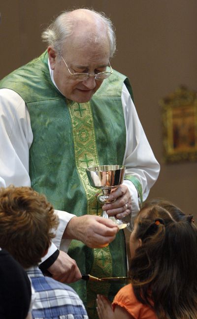 The Rev. Allan Hawkins delivers Communion to a parishioner at Saint Mary the Virgin Catholic Church in Arlington, Texas, on Oct. 25.  (Associated Press / The Spokesman-Review)