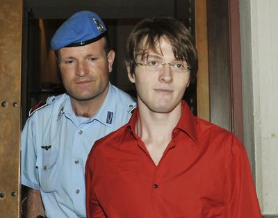 FILE - In this June 26, 2009 file photo, murder suspect Raffaele Sollecito is escorted by a penitentiary police officer as he arrives for a hearing in the Meredith Kercher murder trial, in Perugia, Italy. Sollecito, whose budding love affair with American exchange student Amanda Knox helped land him in an Italian prison for four years, maintains the couple's innocence in a new book but acknowledges that their sometimes bizarre behavior after her roommate's killing gave police reason for suspicion. (Stefano Medici / Associated Press)