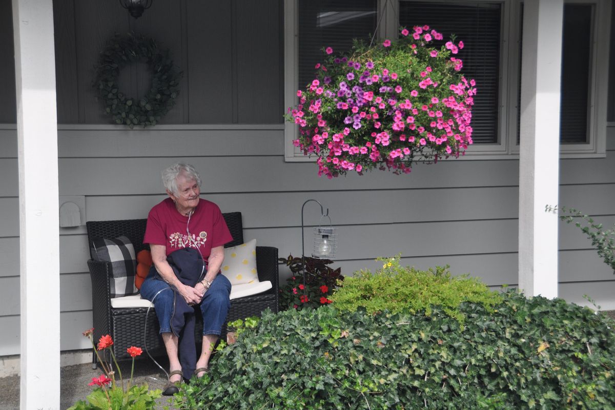 Bobette Tuchek enjoys a basket of Million Bell petunias on her front porch on Spokane’s South Hill. The cooler summer weather has treat the basket kindly this year and it still looks great. (Pat Munts / The Spokesman-Review)