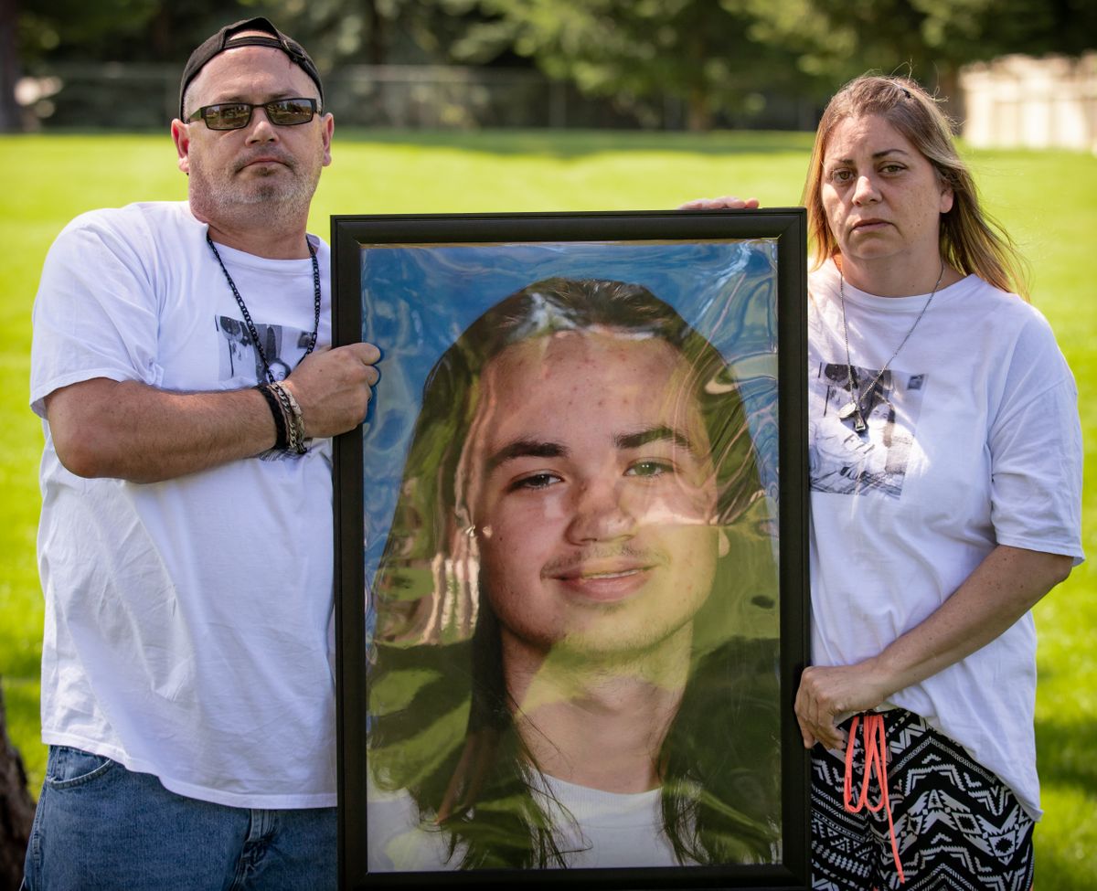 Father Frank Stabile (left) and mother Jennifer Stabile show the portrait of their late son, 15-year-old Michael Stabile, after a gathering in Coeur d