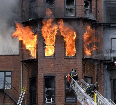Boston firefighters work a fire Wednesday in which two firefighters died. (Associated Press)
