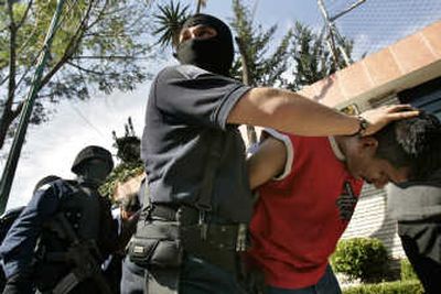 
Mexican federal police officers escort detained men from a home in Mexico City on Tuesday.  Eleven alleged hit men for the powerful Sinaloa drug cartel were captured at two mansions. Associated Press
 (Associated Press / The Spokesman-Review)