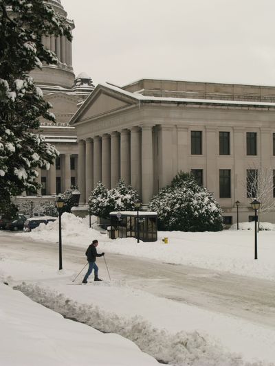 A cross-country skier goes past the state capitol and state insurance building in Olympia on Dec. 22, 2008. (Rich Roesler / The Spokesman-Review)