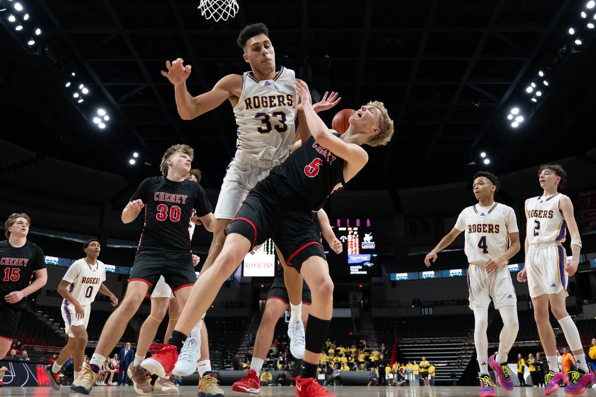 Rogers center Treshon Green blocks a shot by Cheney guard Grayson Burton during the Railroad Rumble game Tuesday at the Arena.  (COLIN MULVANY)