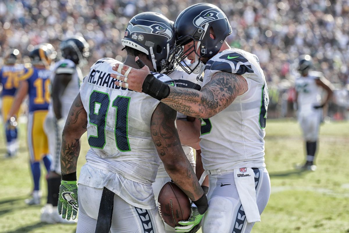 Seattle Seahawks center Justin Britt, right, congratulates defensive lineman Sheldon Richardson after he recovered a fumble during the 2017 season. Britt played six seasons with the Seahawks.  (Tribune News Service)