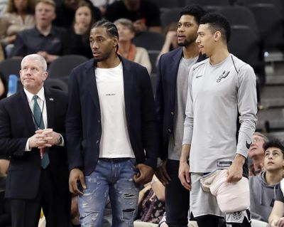 In this Jan. 21, 2018, file photo, San Antonio Spurs guard Danny Green, right, stands at the bench with injured teammates Kawhi Leonard, second from left, and Rudy Gay, center, during the second half of an NBA basketball game against the Indiana Pacers in San Antonio. Leonard plans on returning this season and wants to remain with the Spurs for life, refuting reports of dissension with the star forward and the only franchise he has played for. Leonard has missed all but nine games this season with right quadriceps tendinopathy, which initially flared up late in the offseason. (Eric Gay / Associated Press)