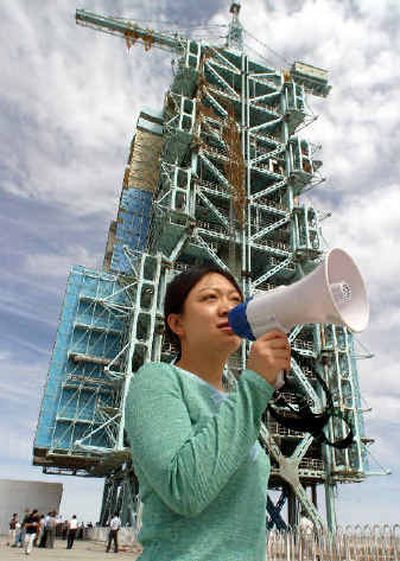 
A Chinese interpreter gathers journalists near the launch platform that launched China's first manned flight last year at the Jiuquan aerospace center near Jiuquan, northwestern China, on Wednesday.  
 (Associated Press / The Spokesman-Review)