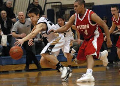 
Mead's Bo Tully slips past Ferris' Erick Cheadle to grab a loose ball during first-half Greater Spokane League boys basketball action on Tuesday night at Mead. 
 (Brian Plonka / The Spokesman-Review)