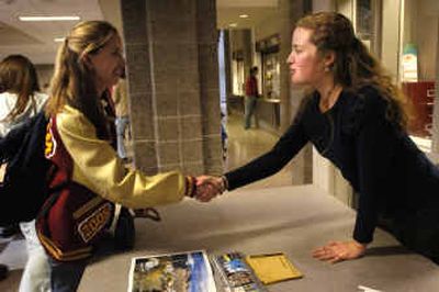 
University of Montana admissions counselor Madeline Mussman, right, congratulates University senior Erika Schlieder on being accepted to UM during a visit to University High on Thursday. The Spokane National College Fair is at the Convention Center on Monday. 
 (Holly Pickett / The Spokesman-Review)