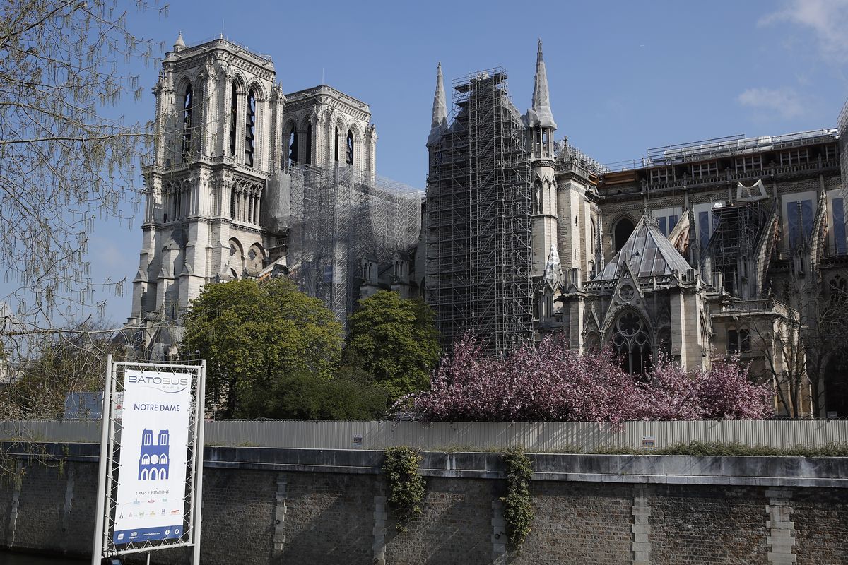 In this file photo dated Thursday, April 15, 2021, Notre Dame cathedral shrouded in scaffolding in Paris. After more than two-years of work to stabilize and protect it after the shocking fire that tore through its roof and knocked down its spire, France’s Notre Dame Cathedral is finally stable and secure enough for artisans to start rebuilding it, according to a government statement Saturday Sept. 18, 2021.  (Francois Mori)