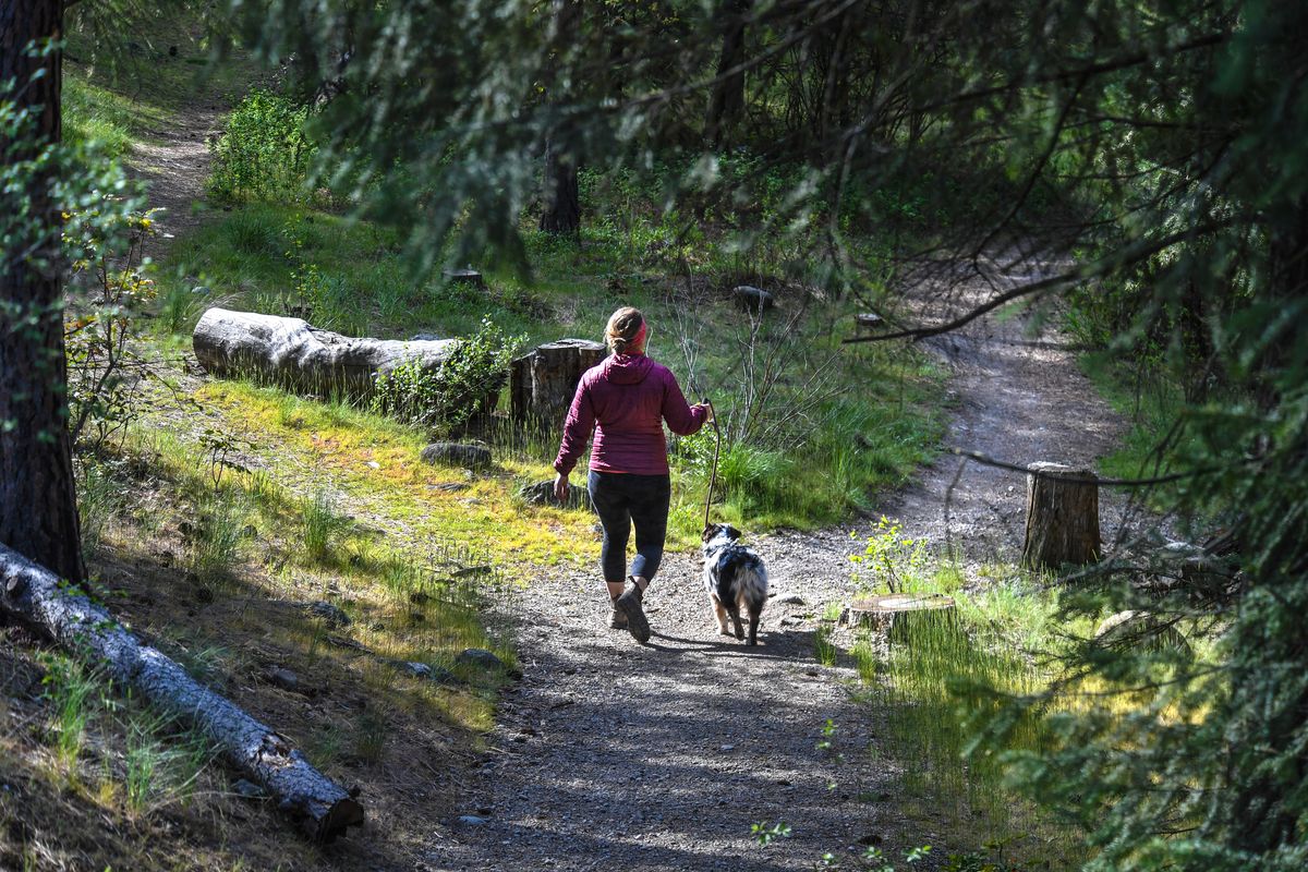 Nicole Wollgast and her dog, Maggie, explore Riverside State Park near the Bowl & Pitcher area on May 5, the first day of state parks reopening since March.  (Dan Pelle/The Spokesman-Review)