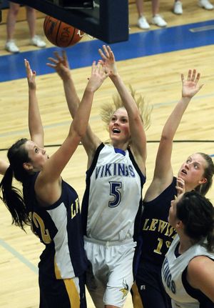 CdA’s Dayna Drager shoots between Lewiston’s Tanis Fuller, left, and Nicole Redd on Tuesday. (Dan Pelle)